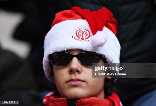 Mainz 05 fan wearing a Christmas hat watches the action during the Bundesliga match between 1. FSV Mainz 05 and 1. FC Union Berlin at Opel Arena on...