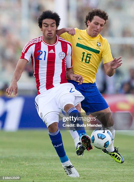 Elano of Brazil struggles for the ball with Marcelo Estigarribia of Paraguay during a match as part of Group B of Copa America 2011 at the Mario...