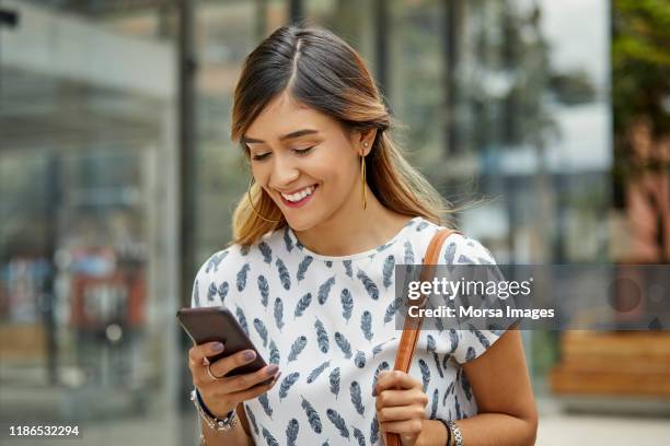mulher de negócios que sorri ao usar o smartphone - povo colombiano - fotografias e filmes do acervo