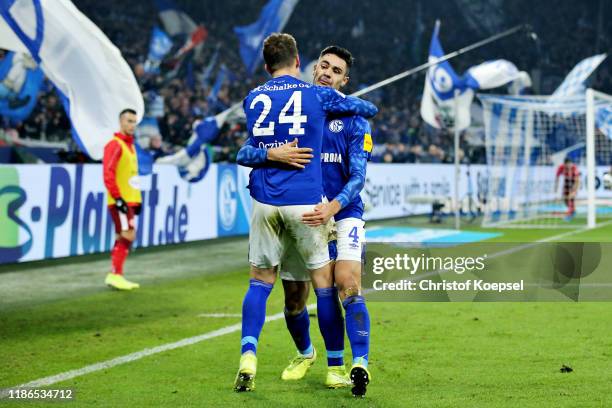 Ozan Kabak of FC Schalke 04 celebrates scoring his sides second goal with teammate Bastian Oczipka during the Bundesliga match between FC Schalke 04...