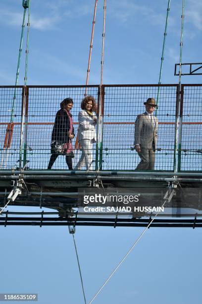 Sweden's King Carl XVI Gustaf and Queen Silvia walk on the Ram Jhula bridge over Ganga river in Rishikesh on December 5, 2019.