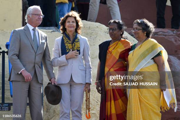 Sweden's King Carl XVI Gustaf and Queen Silvia speak with two female priests as they arrive to attend attend a Ganga Arti Puja, a prayer service, on...