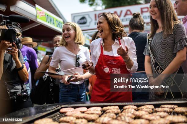 Sen. Kamala Harris, D-Calif, 2020 Democratic Presidential Candidate, shares a laugh as she flips pork chops and hamburger at the Iowa State Fair on...