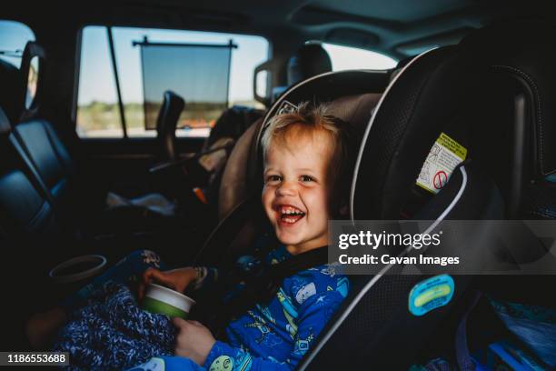 portrait of happy toddler boy in rear facing car seat - toddler in car foto e immagini stock