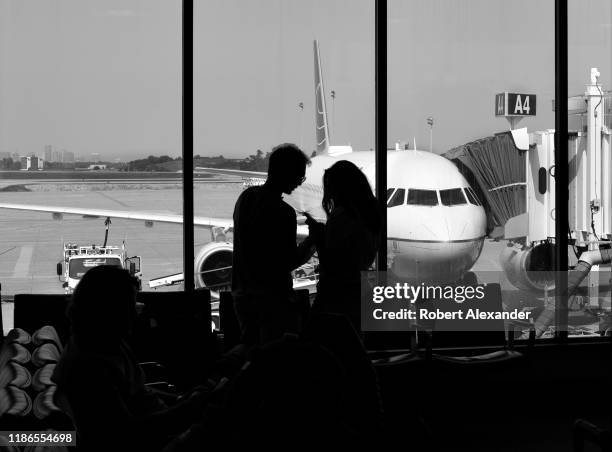 Couple use their smartphones as the wait in the terminal at Nashville International Airport in Nashville, Tennessee.