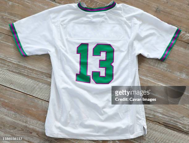 high angle view of t-shirt with number 13 on wooden table - trikot stock-fotos und bilder