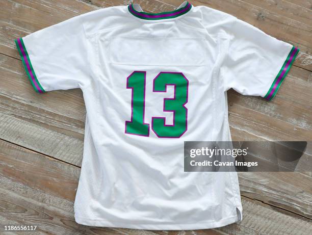 high angle view of t-shirt with number 13 on wooden table - maillot de sport photos et images de collection