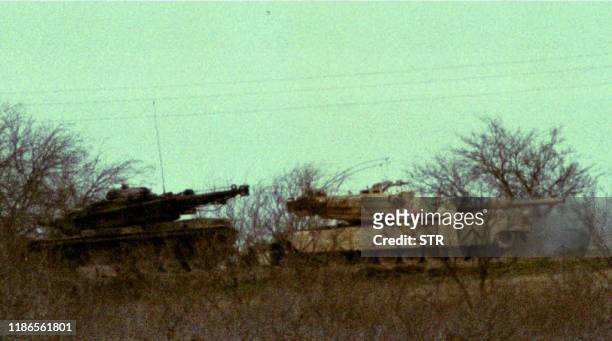 Two M1 Abrams tanks sit in the underbrush about 200 yards from the Branch Davidian cult compound in Texas 10 March 1993. Negotiations to end the...
