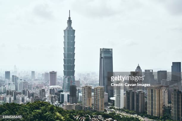 taipei 101 amidst modern buildings against sky in city - taipei stock pictures, royalty-free photos & images