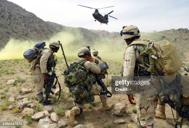 American soldiers prepare to board a helicopter after Operation Deliberate Strike, some 60 kilometers north of Kandahar, Afghanistan, 20 May 2003....