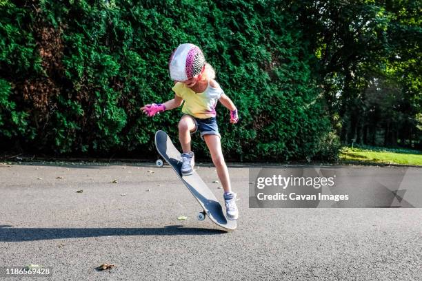 girl doing ollie outside on skateboard - stunt person 個照片及圖片檔