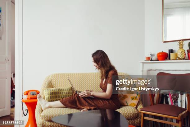 young woman on video call during break - orange dress stock-fotos und bilder