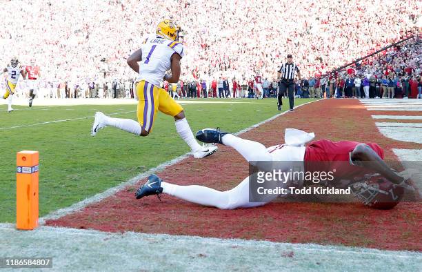 Ja'Marr Chase of the LSU Tigers scores a 33-yard receiving touchdown during the first quarter as Trevon Diggs of the Alabama Crimson Tide falls down...