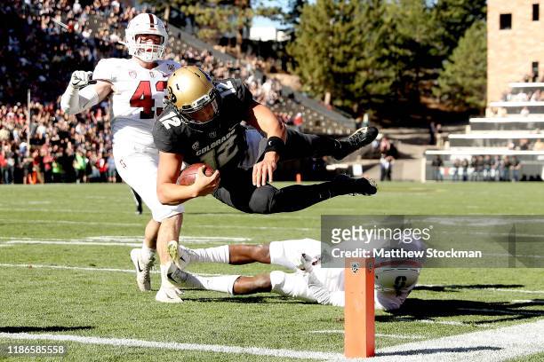 Quarterback Steven Montez of the Colorado Buffaloes scores a touchdown against Ryan Beecher and Paulson Abedo of the Stanford Cardinal in the first...