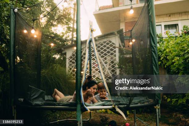 mother and son on a trampoline, using digital tablet - watching ipad stock pictures, royalty-free photos & images