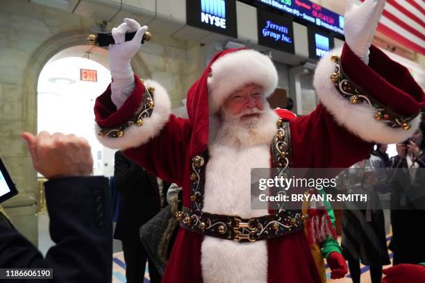 Man in a Santa Claus costume gestures on the floor at the closing bell of the Dow Industrial Average at the New York Stock Exchange on December 5,...