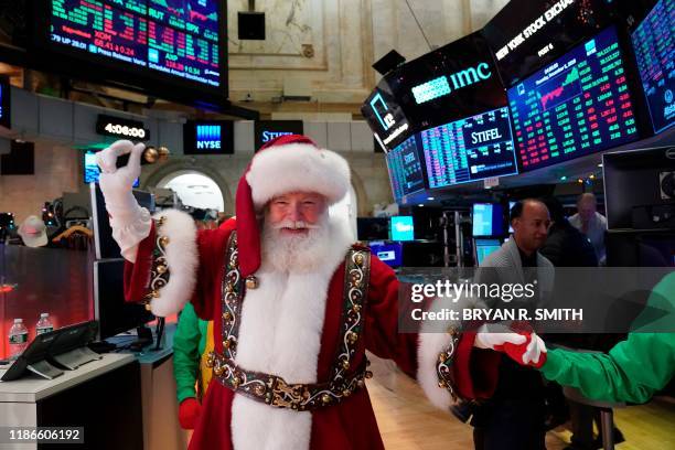 Man in a Santa Claus costume gestures on the floor at the closing bell of the Dow Industrial Average at the New York Stock Exchange on December 5,...