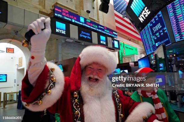 Man in a Santa Claus costume gestures on the floor at the closing bell of the Dow Industrial Average at the New York Stock Exchange on December 5,...