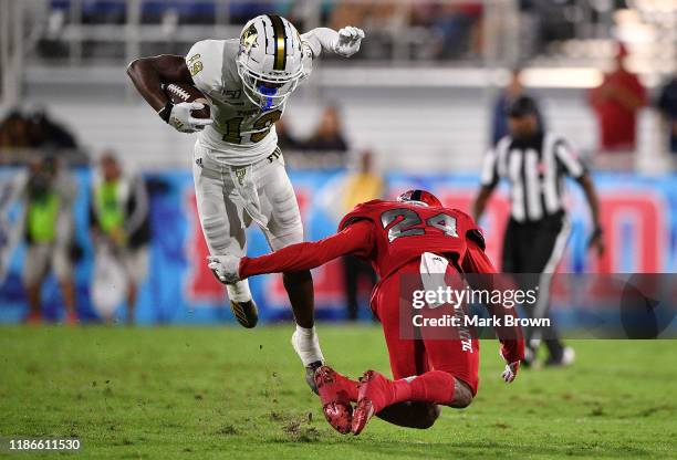 Shemar Thornton of the FIU Golden Panthers tries to avoid Zyon Gilbert of the Florida Atlantic Owls in the first quarter at FAU Stadium on November...