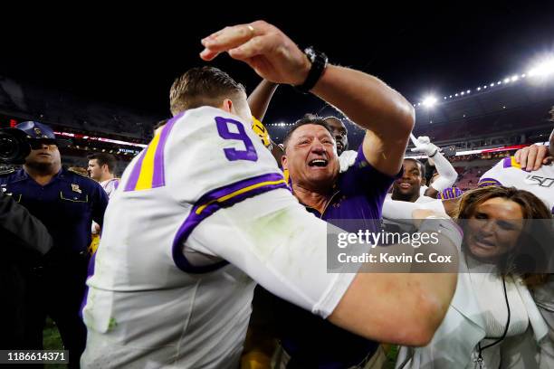 Joe Burrow of the LSU Tigers celebrates with head coach Ed Orgeron after defeating the Alabama Crimson Tide 46-41 at Bryant-Denny Stadium on November...