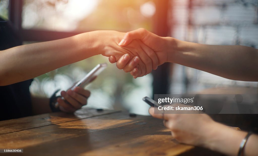 Close up business female shaking hand for accept deal at cafe