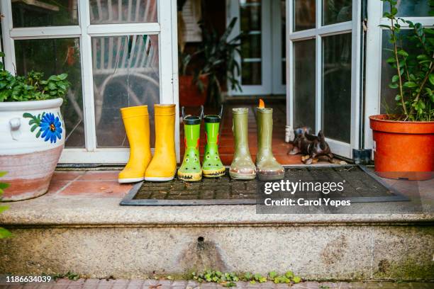 family rainboots at home entrance - rubber boots imagens e fotografias de stock