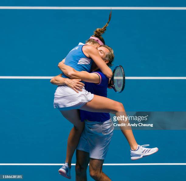 Kristina Mladenovic of France celebrates with French Captain Julien Benneteau after winning the Day 2 match against Ashleigh Barty of Australia in...