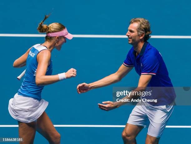 Kristina Mladenovic of France celebrates with French Captain Julien Benneteau after winning the Day 2 match against Ashleigh Barty of Australia in...