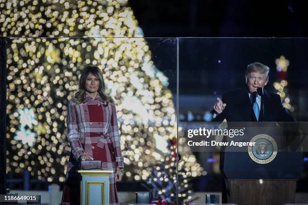 President Donald Trump looks on as first lady Melania Trump pressed a button to light the National Christmas Tree during a lighting ceremony held by...