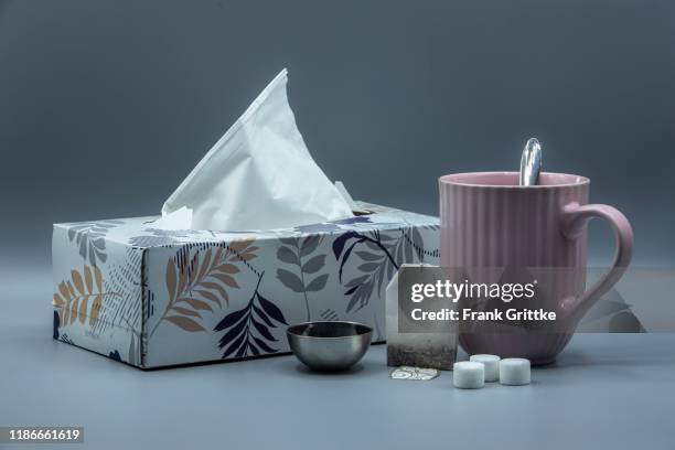 wintertime with a cup of tea and handkerchiefs - virus grippe stock pictures, royalty-free photos & images