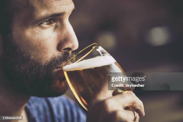 primo posto di un uomo pensieroso e adulto che beve birra in un pub. - beer close up foto e immagini stock