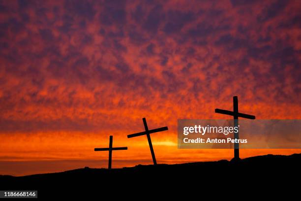 three christian crosses on a hill at sunset. religion concept - easter church stock-fotos und bilder