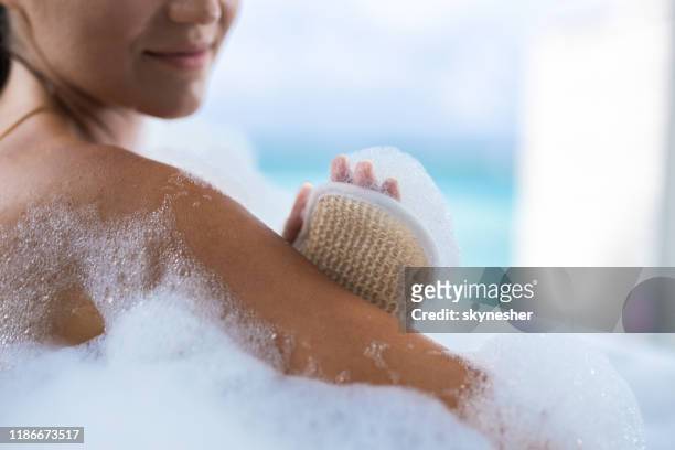 close up of a woman taking a bath. - scrubbing brush stock pictures, royalty-free photos & images