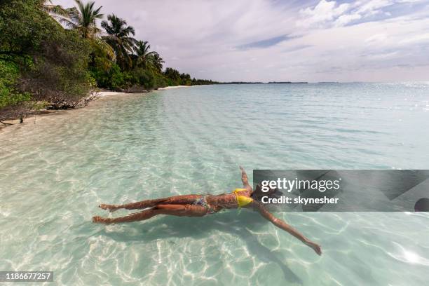entspannte frau schwimmen auf dem wasser im sommertag. - indischer ozean stock-fotos und bilder