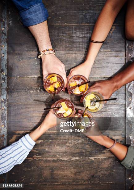 freundschaft ist der klebstoff, der das leben zusammenhält - friends toasting above table stock-fotos und bilder