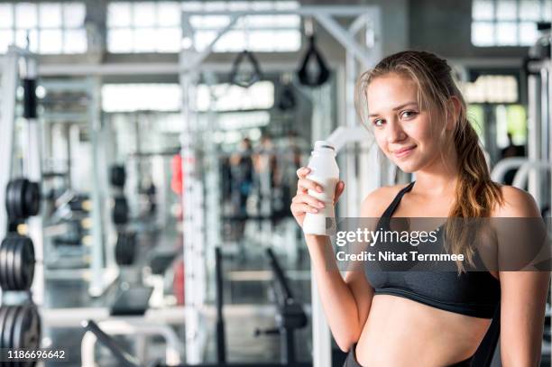 healthy lifestyle exercising and diet concepts. young women drink milk from bottles after exercise traning at gym. - calcio sport imagens e fotografias de stock