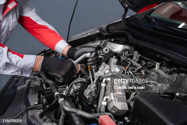 車の中でエンジンを分解するオートメカニック - 自動車整備工 ストックフォトと画像