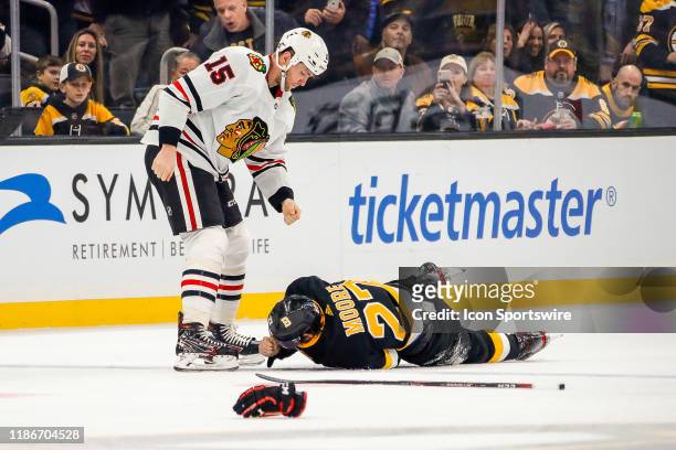 Boston Bruins defenseman John Moore falls to ice after punch from Chicago Blackhawks center Zack Smith during the Chicago Blackhawks and Boston...