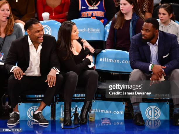 Latrell Sprewell, guest and Justin Tuck attend Denver Nuggets v New York Knicks game at Madison Square Garden on December 5, 2019 in New York City.
