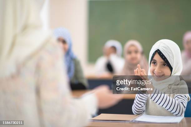 elementary muslim student clapping stock photo - afghani stock pictures, royalty-free photos & images