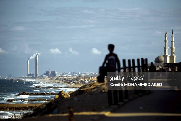 Picture taken on December 6 shows a general view of buildings in al-Shati refugee camp in Gaza City and the Israeli port city of Ashkelon on the...