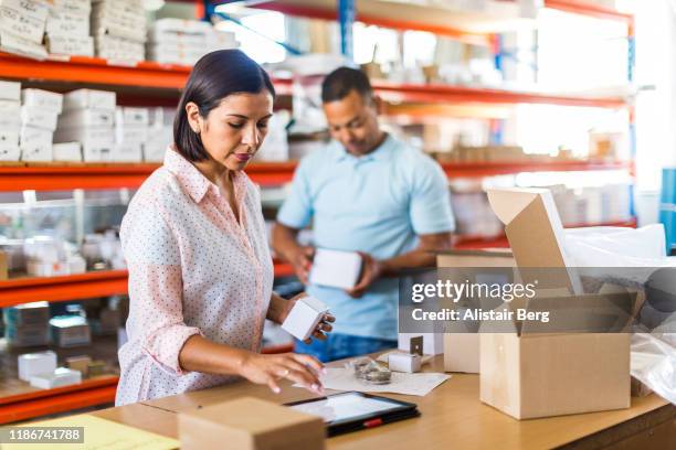 female manager using tablet computer in a small business - busy warehouse stock pictures, royalty-free photos & images