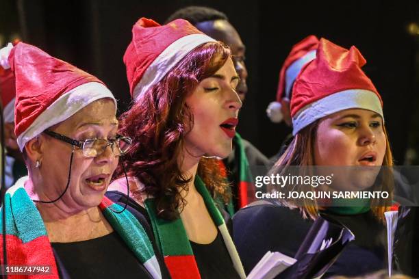 Victims and former members of guerrillas and paramilitary groups sing in a choir with the Medellin Philharmonic Orchestra during a christmas concert...