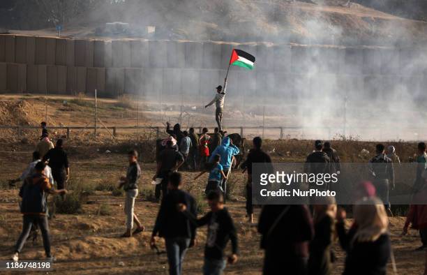 Palestinian protesters run from tear gas fired by Israeli forces amid clashes during a demonstration along the border with Israel east of Bureij in...