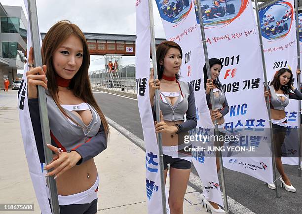 South Korean models pose with flags for the upcoming Korean Formula One Grand Prix during an event to mark the 100-day countdown to the race at the...