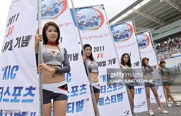 South Korean models hold flags for the upcoming Korean Formula One Grand Prix during an event to mark the 100-day countdown to the race at the Korean...