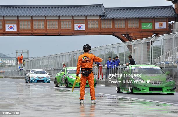 Track official controls sports cars in the pit lane during an event to mark the 100-day countdown to the upcoming Korean Formula One Grand Prix at...