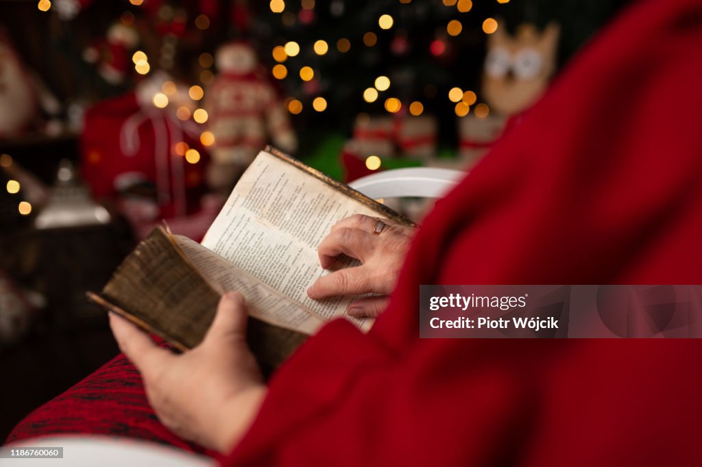 Grandmother reads the Holy Bible in Christmas arrangement