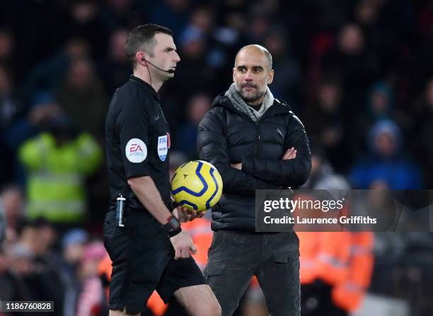 Pep Guardiola, Manager of Manchester City stares at referee Michael Oliver as he walks onto the pitch for the second halfduring the Premier League...