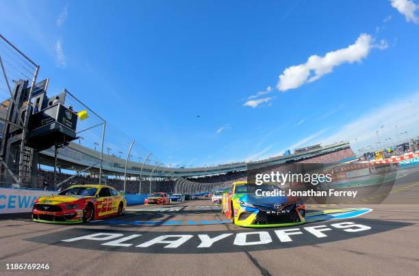 Kyle Busch, driver of the M&M's Toyota,and Joey Logano, driver of the Shell Pennzoil Ford, lead the field to the green flag at the satrt of the...